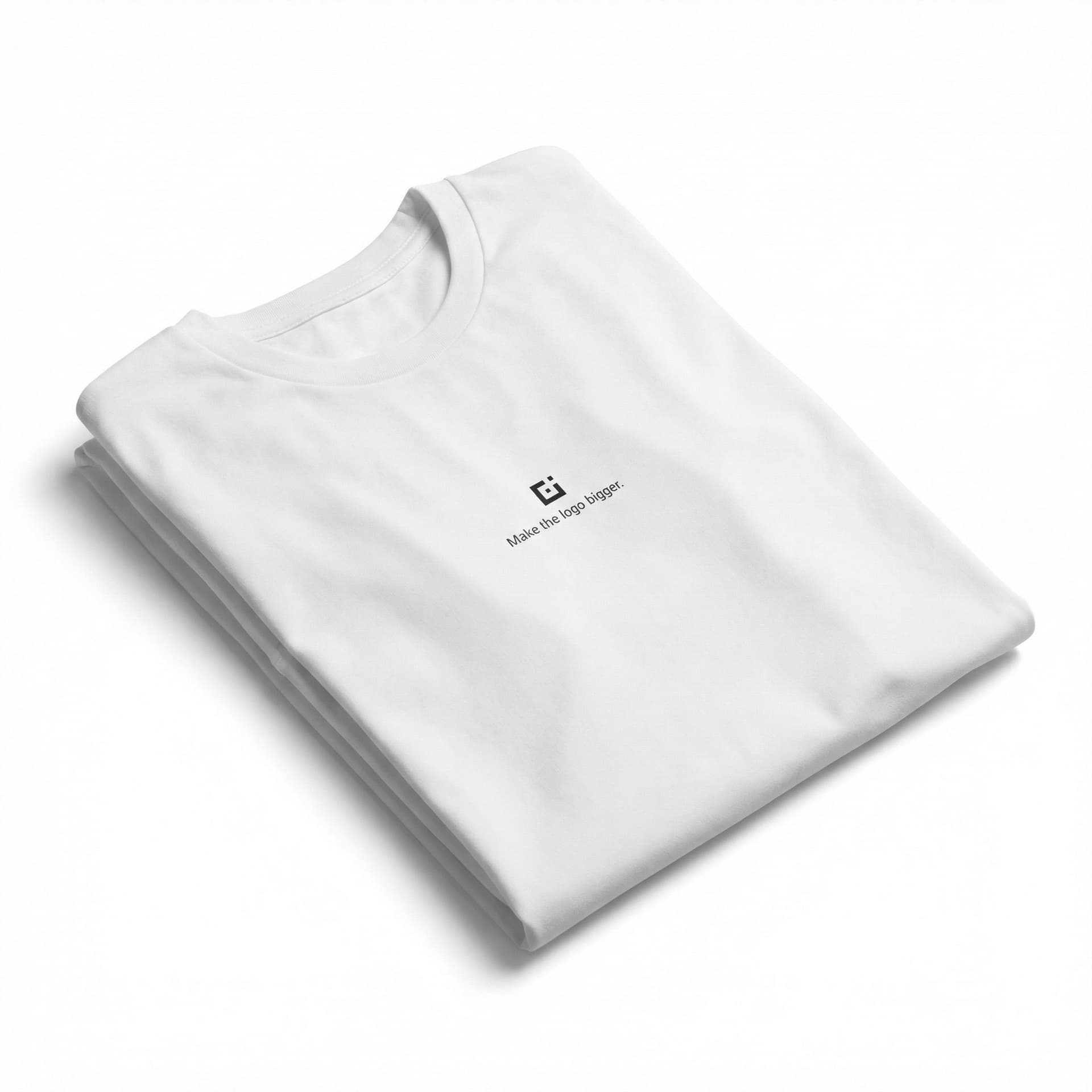 A minimalist t-shirt graphic design. A vast, empty white space centered on the shirt. In the dead center, a microscopic, minuscule, tiny geometric abstract logo icon. Directly below the tiny icon, in very small, subtle, sans-serif font, the text "Make the logo bigger.". The aesthetic is extreme minimalism and irony. Screen printed on fabric. --ar 1:1