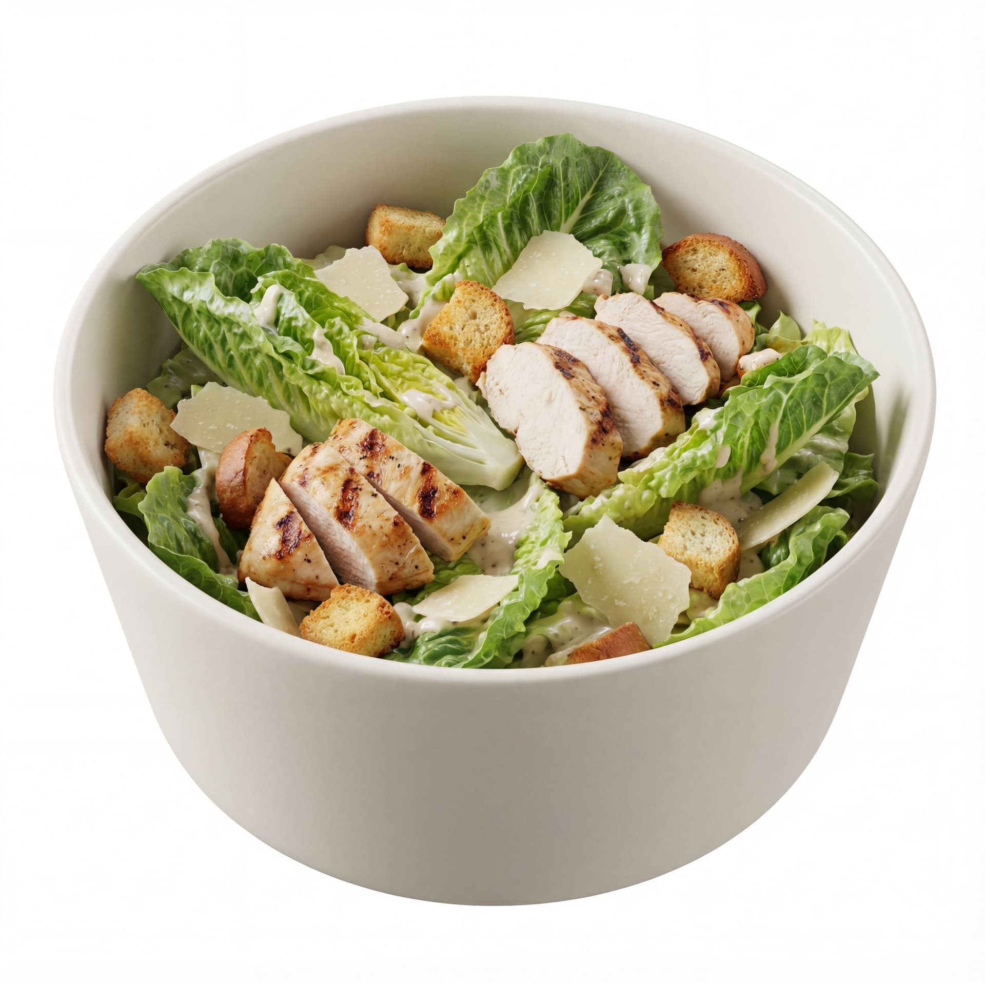 A tall bowl containing Caesar salad with romaine leaves, grilled chicken slices, parmesan flakes, and croutons.